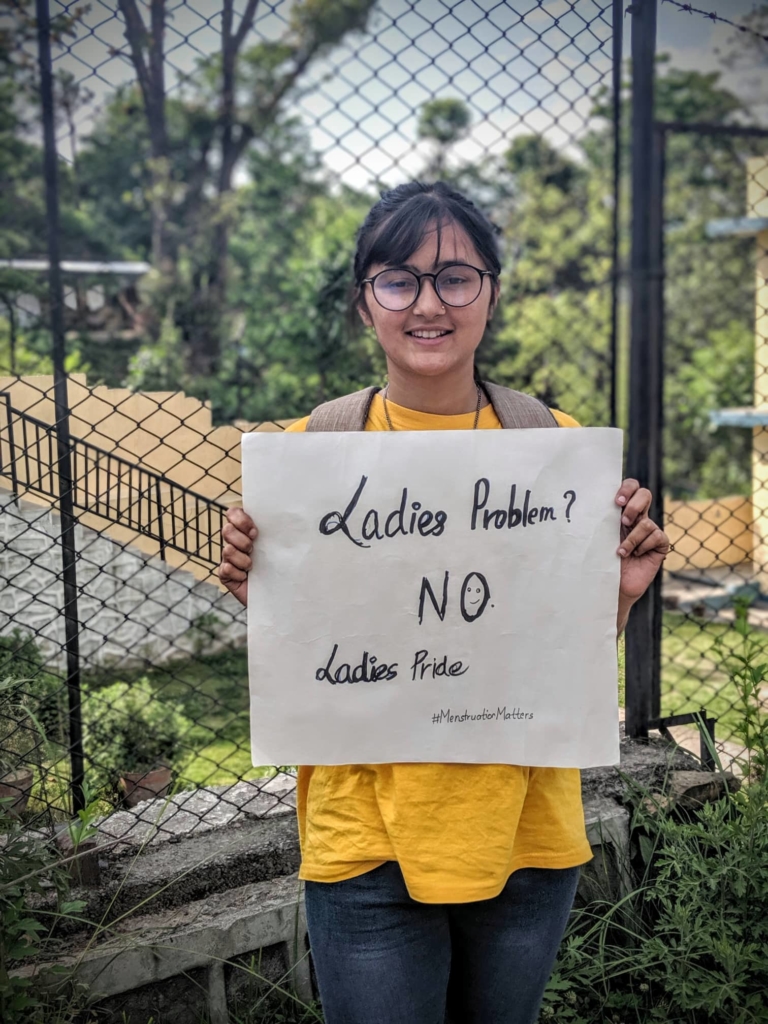 Samikshya Koirala, 21, is a youth executive from Amnesty International Nepal. She is holding a sign that reads "Ladies Problem? NO. Ladies Pride. #MenstruationMatters"